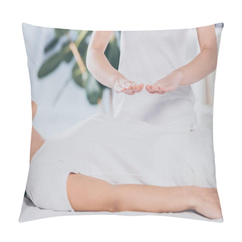 Personality  cropped shot of calm young woman receiving reiki healing treatment on stomach  pillow covers