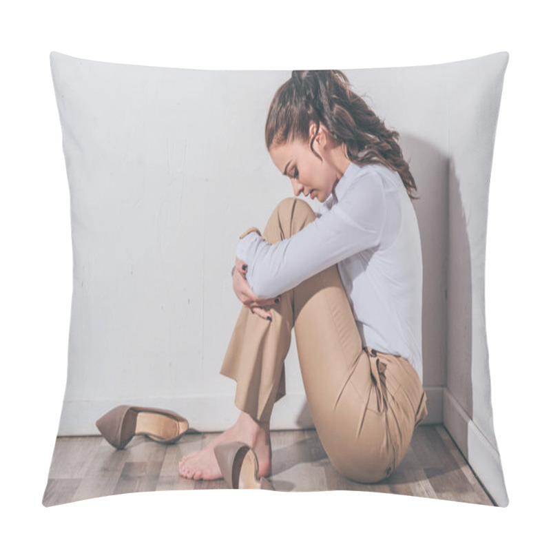 Personality  sad woman in white blouse and beige pants sitting on floor with head bent near white wall at home, grieving disorder concept pillow covers