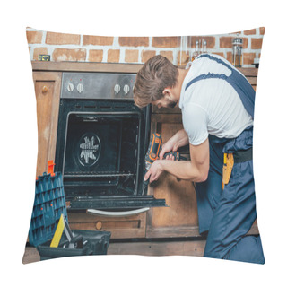 Personality  Young Repairman In Protective Workwear Fixing Oven With Electric Drill Pillow Covers