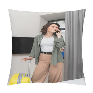 Personality  Positive Woman With Brunette Hair, In Casual Clothes, Shirt And Pants, Talking On Mobile Phone While Standing Near Yellow Suitcase, Window, Grey Curtains And Lcd Tv With Blank Screen In Hotel Room Pillow Covers