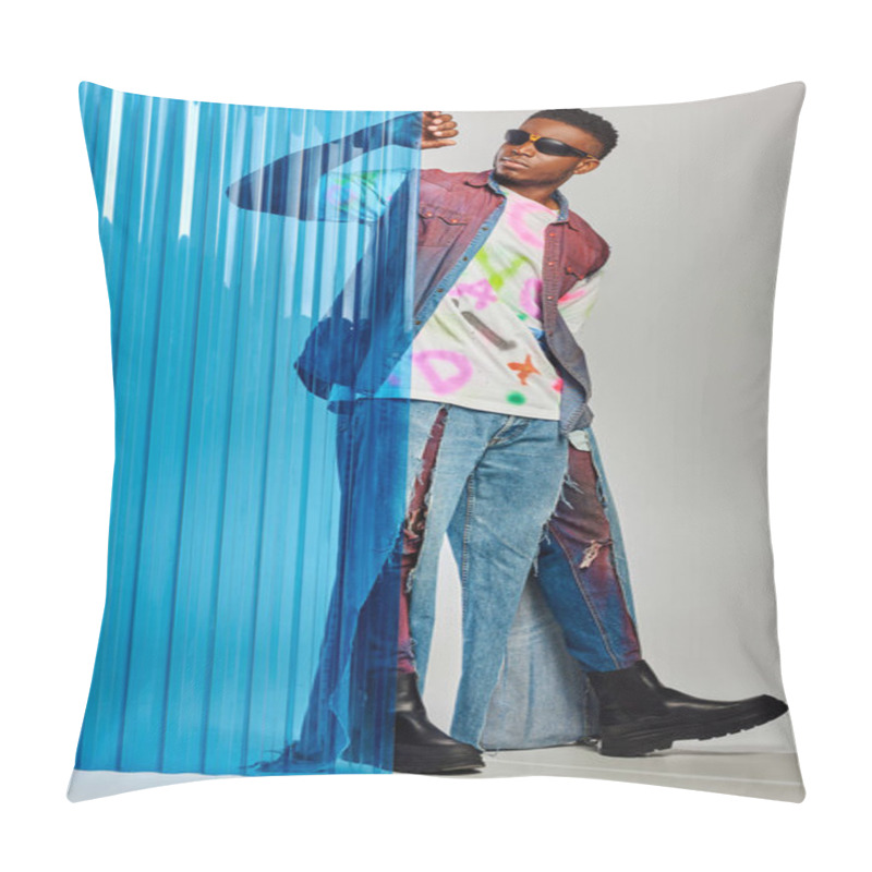 Personality  Full length of handsome afroamerican model in sunglasses denim vest and ripped jeans touching blue polycarbonate sheet and standing on grey background, DIY clothing, sustainable lifestyle  pillow covers