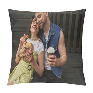 Personality  Joyful And Stylish Woman In Sundress Holding Fresh Bun And Sitting Near Bearded Boyfriend In Denim Vest Holding Takeaway Coffee And Wooden House At Background, Serene Ambiance Concept Pillow Covers