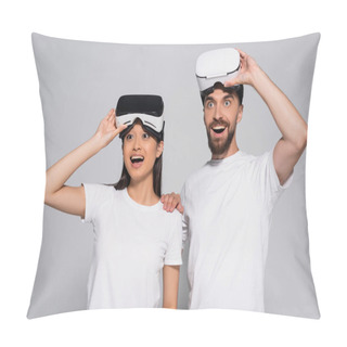 Personality  Excited Interracial Couple In White T-shirts Looking Away With Open Mouths While Touching Vr Headsets On Grey Pillow Covers