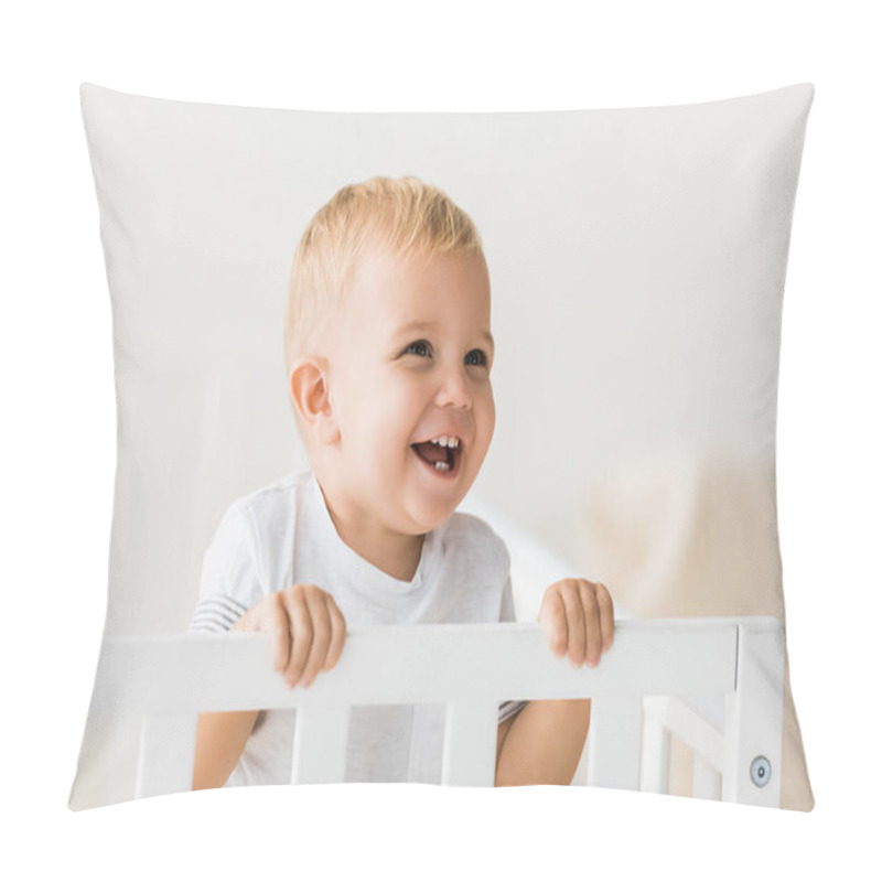 Personality  cheerful toddler standing in baby crib on white background pillow covers