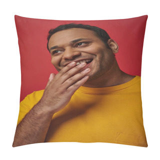 Personality  Shy Indian Man In Yellow T-shirt Smiling And Covering Mouth With Hand On Red Background In Studio Pillow Covers