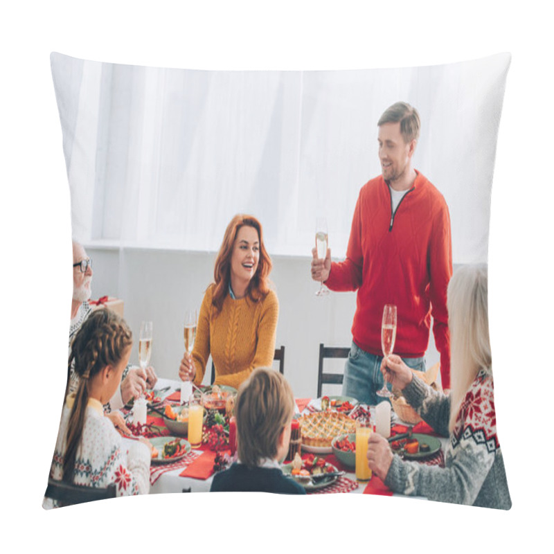 Personality  Smiling man with champagne glass saying speech near family at festive table at home pillow covers