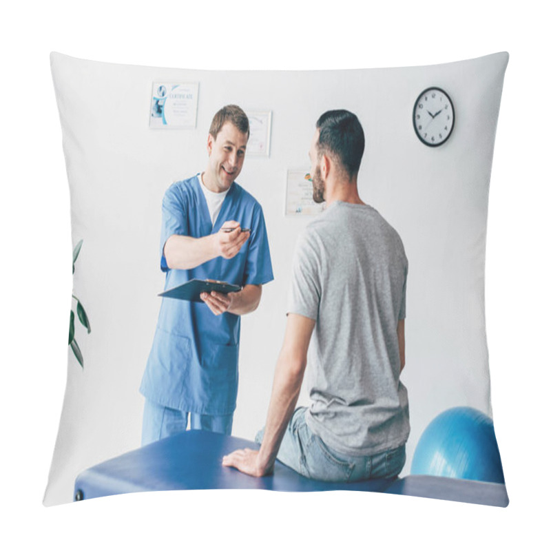Personality  Smiling Physiotherapist With Diagnosis And Pen Gesturing Near Patient In Hospital Pillow Covers