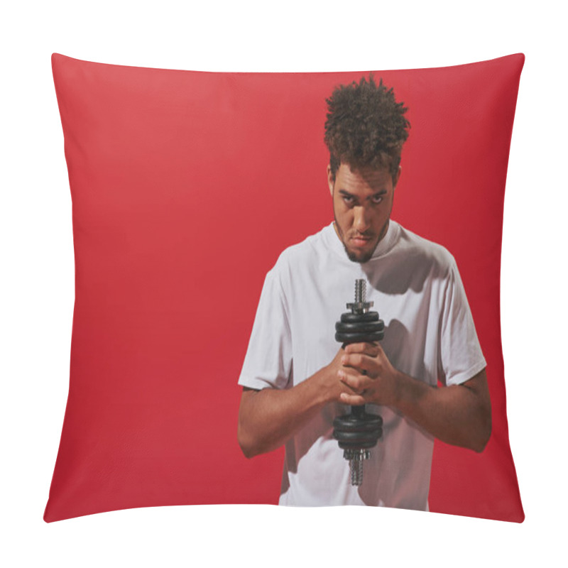 Personality  african american man in sportswear working out with dumbbell and looking at camera on red background pillow covers