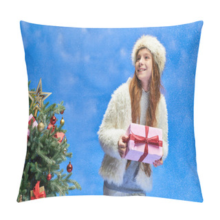 Personality  Excited Girl In Faux Fur Jacket And Hat Holding Gift Under Falling Snow Near Christmas Tree On Blue Pillow Covers