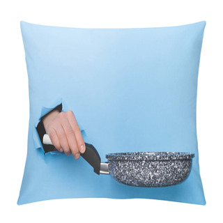 Personality  Close Up Of Female Hand Holding Frying Pan Through Torn Paper Blue Background. Kitchen Utensils Concept. Copy Space For Advertisement Pillow Covers