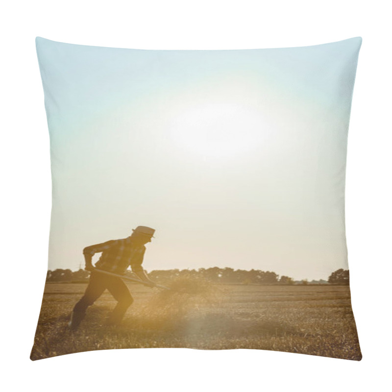 Personality  side view of senior man in straw hat holding rake with hay in wheat field  pillow covers