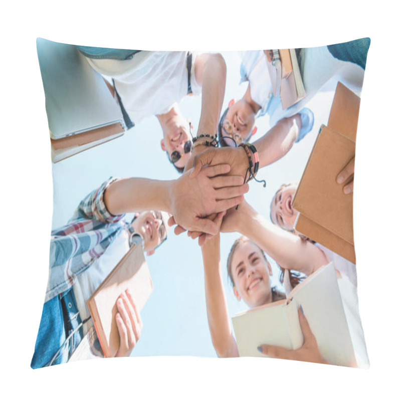 Personality  bottom view of happy multiethnic teenage classmates stacking hands in park   pillow covers