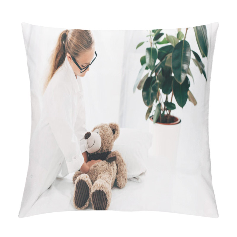 Personality  kid in doctor costume doing heart massage to teddy bear pillow covers