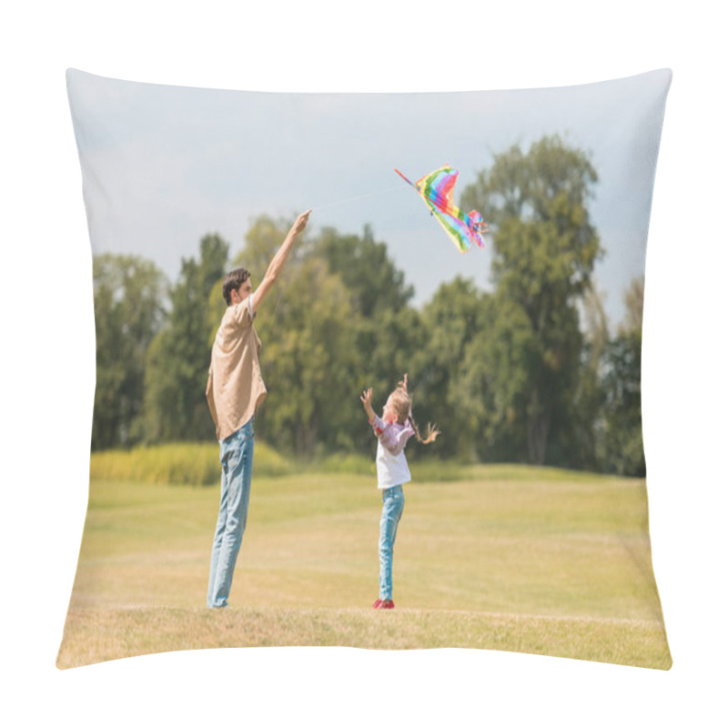 Personality  side view of happy father and little daughter playing with colorful kite in park pillow covers