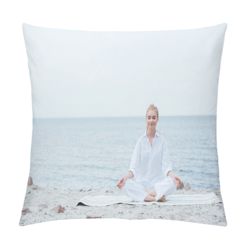 Personality  happy blonde young woman with closed eyes sitting on yoga mat  pillow covers