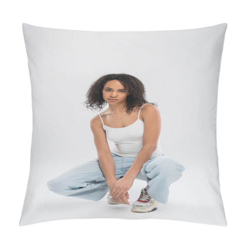 Personality  Full Length Of African American Woman In White Tank Top And Jeans With Sneakers Sitting On Haunches On Grey Background Pillow Covers