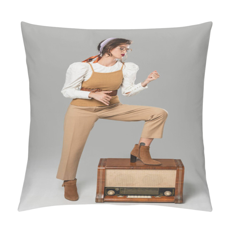 Personality  full length view of trendy young woman imitating playing guitar near vintage radio receiver on grey pillow covers
