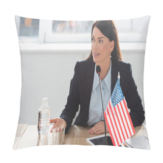 Personality  Smiling Woman In Formal Wear Looking Away, While Speaking In Microphone, Sitting Near American Flags In Boardroom Pillow Covers