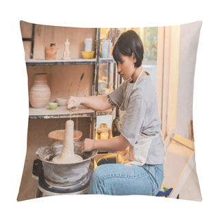 Personality  Side View Of Young Asian Female Artisan In Apron Pouring Water From Sponge On Wet Clay On Pottery Wheel And Working In Ceramic Workshop At Sunset, Pottery Tools And Equipment Pillow Covers