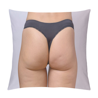 Personality  Trim Toned Buttocks Of A Slender Fit Woman Wearing G-string Black Panties In A Close Up Cropped View Over Grey Pillow Covers