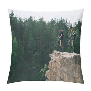 Personality  Side View Of Young Trial Bikers With Backpacks Standing On Back Wheels On Rocky Cliff With Blurred Pine Forest On Background Pillow Covers