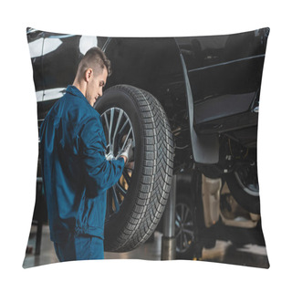 Personality  Young Mechanic Installing Wheel On Raised Car In Workshop Pillow Covers