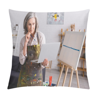 Personality  Mature Woman Holding Paintbrush And Laptop While Watching Tutorial Near Canvas Pillow Covers