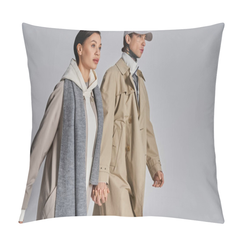 Personality  A stylish man and woman confidently walking and wearing trench coats in a studio against a grey background. pillow covers