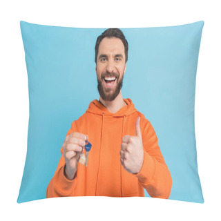 Personality  Cheerful Bearded Man In Orange Hoodie Holding Key And Showing Thumb Up Isolated On Blue Pillow Covers