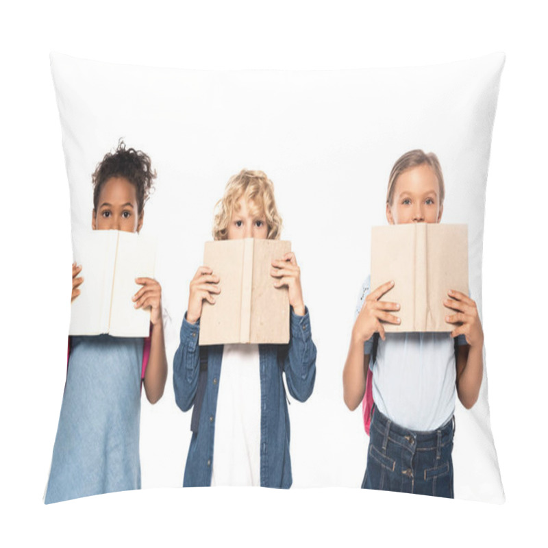 Personality  multicultural schoolgirls and schoolboy covering faces with books and looking at camera isolated on white  pillow covers