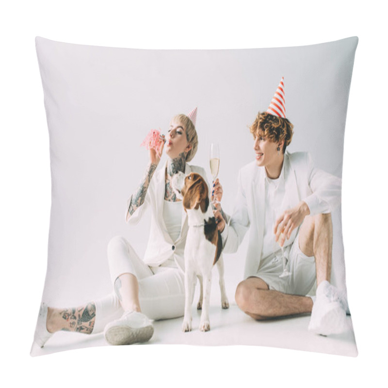 Personality  woman blowing in blower while man holding glasses with champagne while sitting near beagle dog on grey background pillow covers