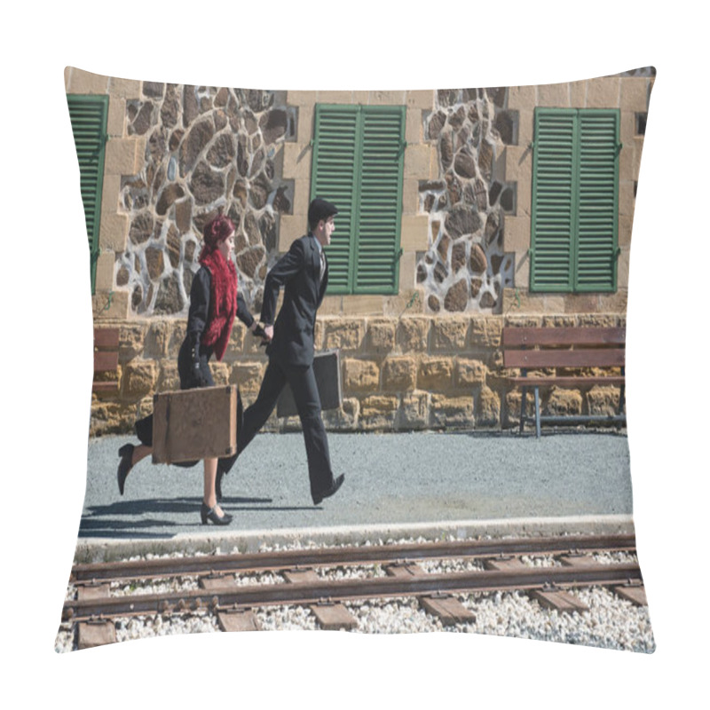 Personality  Young couple with vintage suitcase running fast outside a train station to catch the last train for journey.  pillow covers