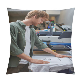 Personality  Side View Of Young Redhead Craftsman Working With T-shirt And Screen Printing Machine In Blurred Print Studio At Background, Customer-focused Small Business Concept Pillow Covers