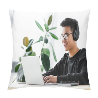 Personality  Smiling Asian Hacker In Headphones Using Laptop And Sitting At Table  Pillow Covers