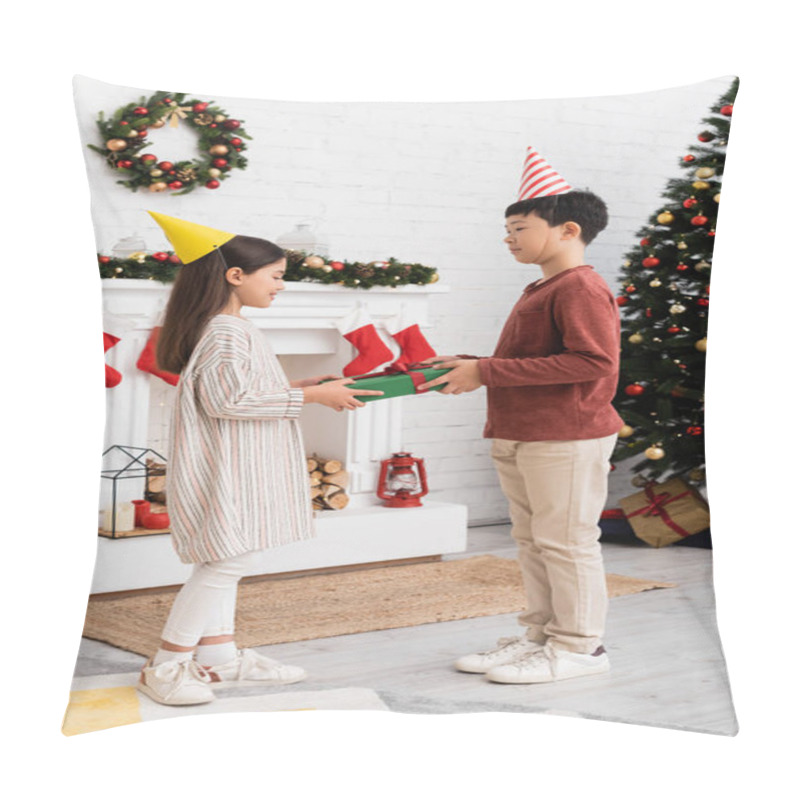 Personality  Multiethnic children in party caps holding present near christmas decor on fireplace at home  pillow covers