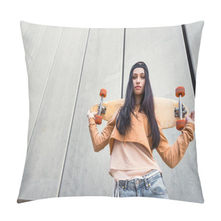 Personality  Low Angle View Of Brunette Woman In Casual Wear Standing Near Concentrate Wall, Holding Skateboard Behind Back, Looking At Camera Pillow Covers
