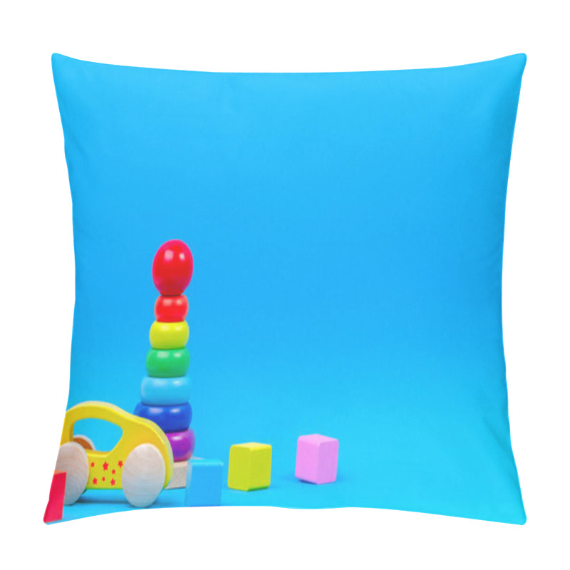 Personality  Baby kid toy background. Wooden toy train, baby stacking rings pyramid and colorful blocks on blue background pillow covers