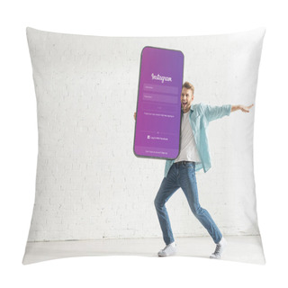 Personality  KYIV, UKRAINE - FEBRUARY 21, 2020: Positive Man Holding Huge Model Of Smartphone With Instagram App At Home Pillow Covers