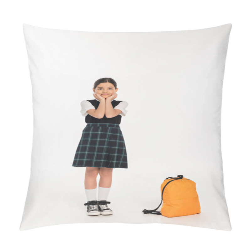 Personality  happy girl in school uniform standing near backpack on white background, back to school, full length pillow covers