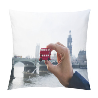 Personality  The Hand Of A Caucasian Man Holding A Miniature Of A Red Double-decker Bus, Typical Of London, United Kingdom, With The Westminster Bridge And The The Palace Of Westminster In The Background Pillow Covers