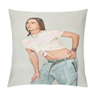 Personality  Tattooed And Young Gay Man With Long Hair Standing In Denim Jeans And Tied Knot On T-shirt Showing His Belly And Posing During Pride Month On Grey Background Pillow Covers
