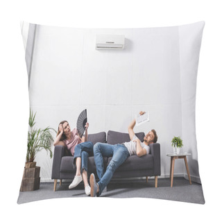 Personality  Young Couple With Hand Fan And Newspaper Suffering From Heat At Home With Broken Air Conditioner  Pillow Covers