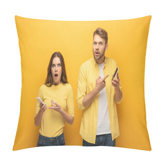 Personality  Excited Couple Looking At Camera And Pointing On Smartphones On Yellow Background Pillow Covers