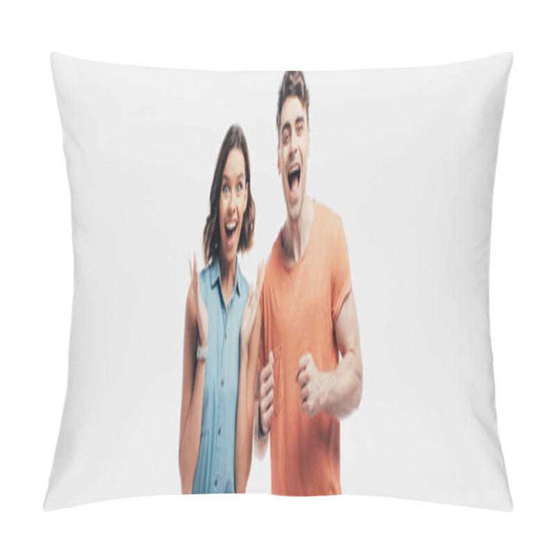 Personality  excited man and woman looking at camera and showing yes gestures isolated on grey pillow covers