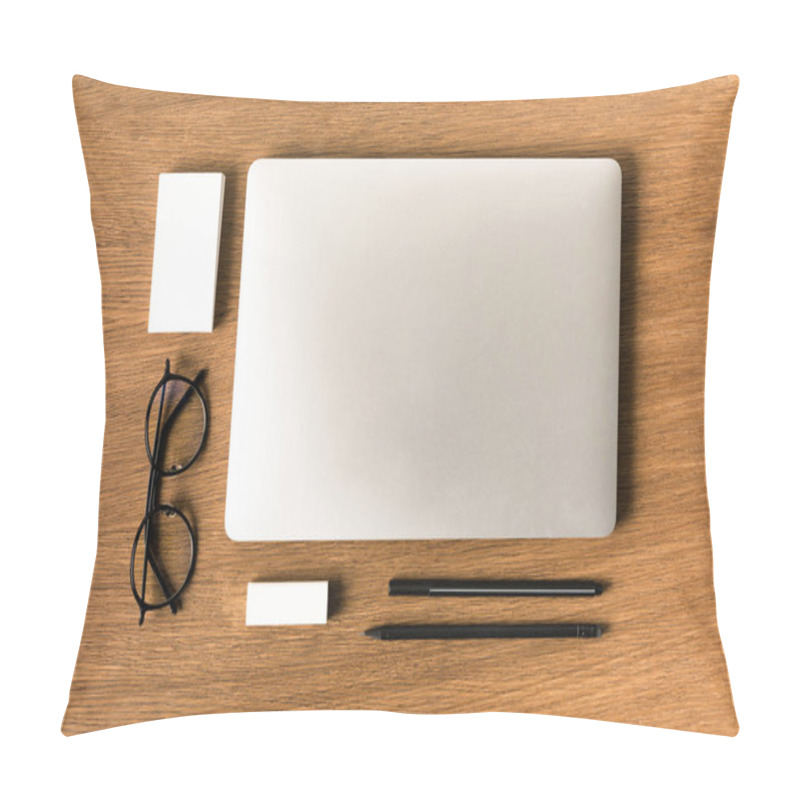 Personality  flat lay with arranged laptop, eyeglasses, blank cards, pen and pencil on wooden tabletop pillow covers