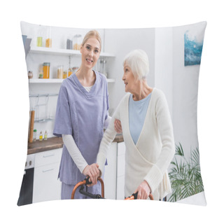 Personality  Young Nurse Smiling At Camera While Supporting Aged Woman Near Medical Walkers Pillow Covers