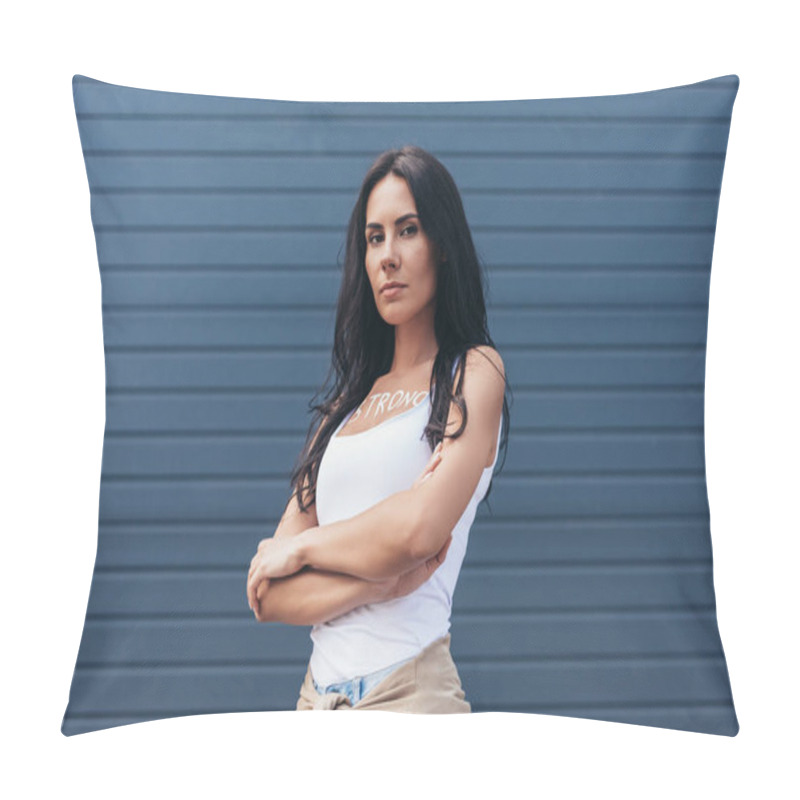 Personality  serious feminist with inscription strong on body standing with crossed arms and looking at camera on street pillow covers