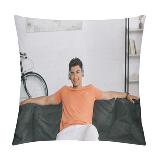 Personality  Cheerful Asian Man Smiling At Camera While Sitting On Sofa And Listening Music In Headphones Pillow Covers