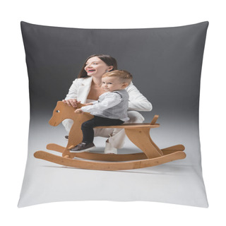 Personality  Cheerful Young Woman Smiling Near Son Riding Rocking Horse On Grey Pillow Covers
