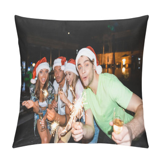 Personality  Selective Focus Of Man In Santa Hat Holding Glass Of Champagne And Sparkler Near Friends And Swimming Pool At Night  Pillow Covers